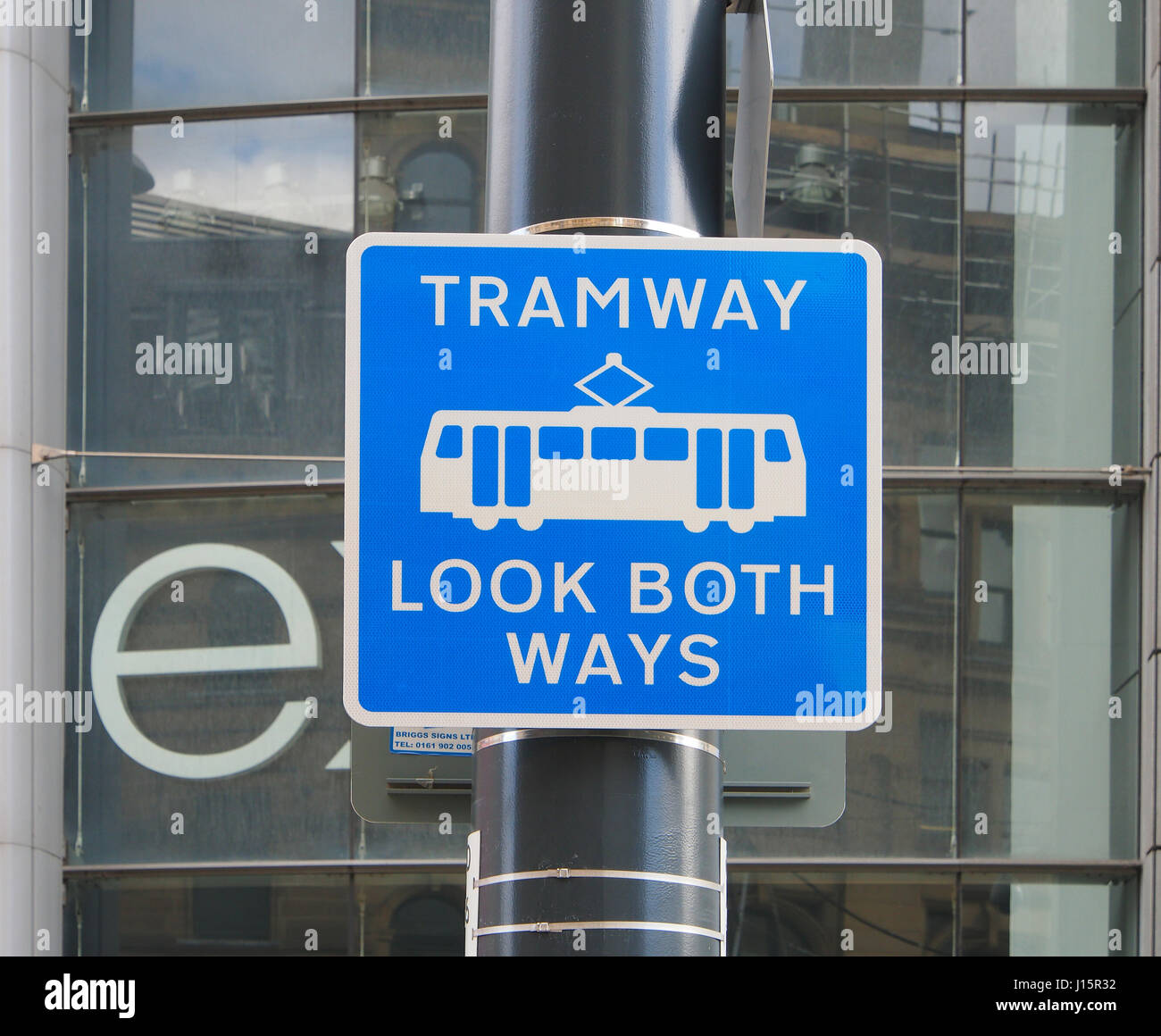 Warniing sign next to the Metrolink tram tramway lines, outside Next in Manchester city center centre. Tramway look both ways. Stock Photo