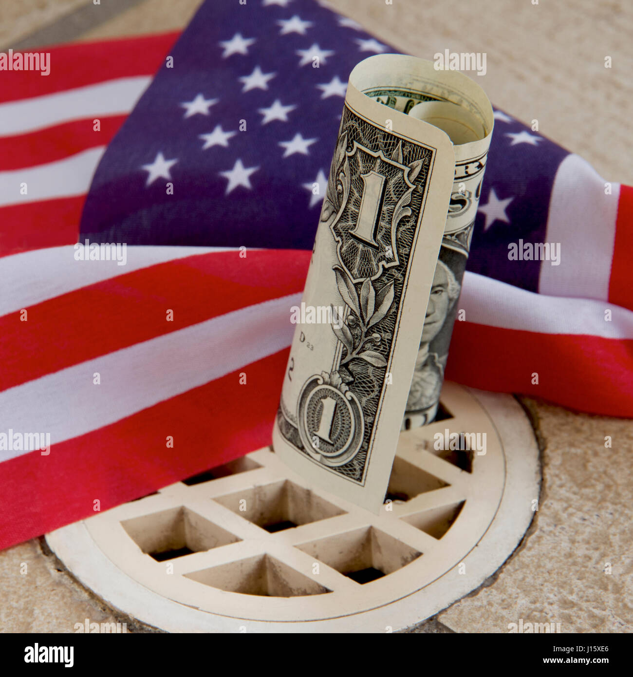 An American dollar down the drain with a flag Stock Photo Alamy