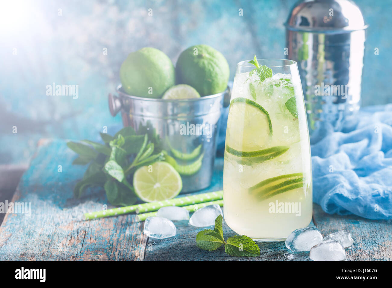 Mojito cocktail with lime and mint in highball glass on blue background ...