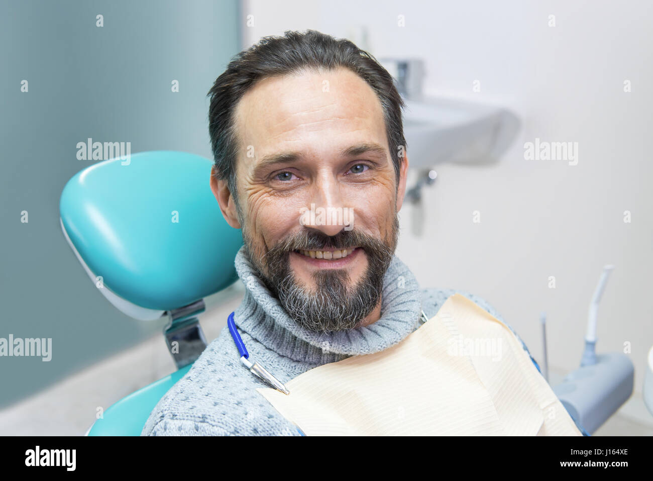 Улыбающийся мужчина в стоматологическом кресле