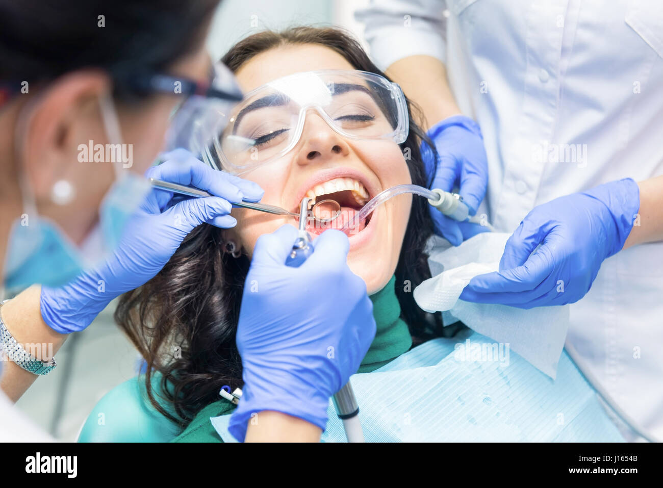 Two dentists busy with patient. Person in dental safety glasses Stock