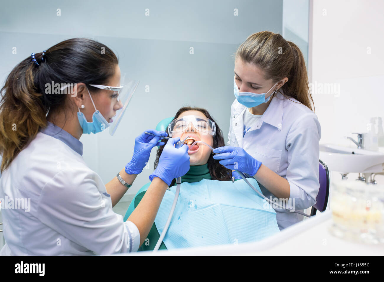 Patient with two dental doctors. Procedure at dentist office. Therapy
