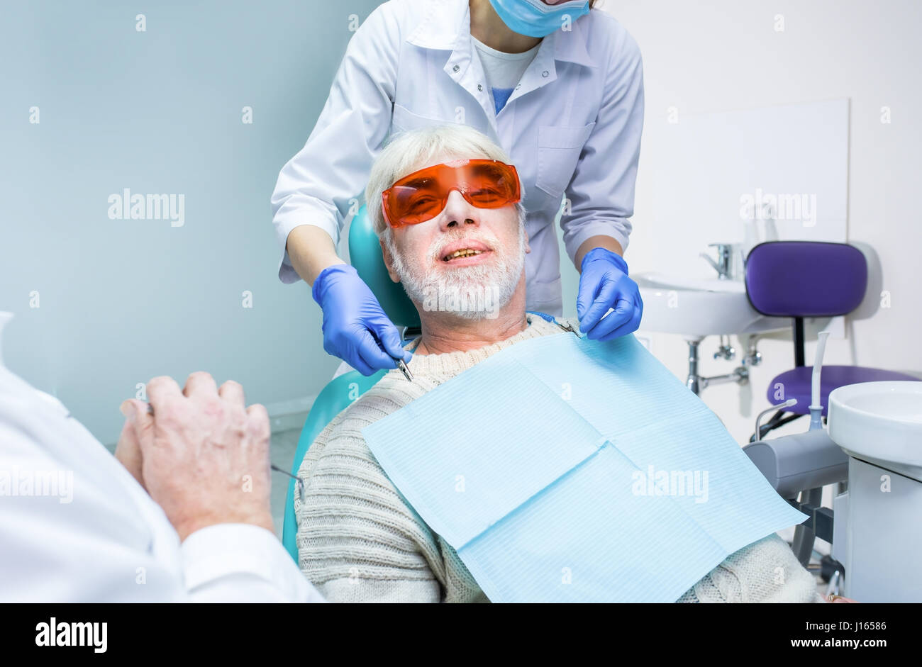 Dentist with elderly patient. Senior man in dental chair Stock Photo