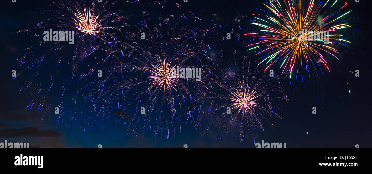 Multicolor fireworks with cityscape at night time Stock Photo