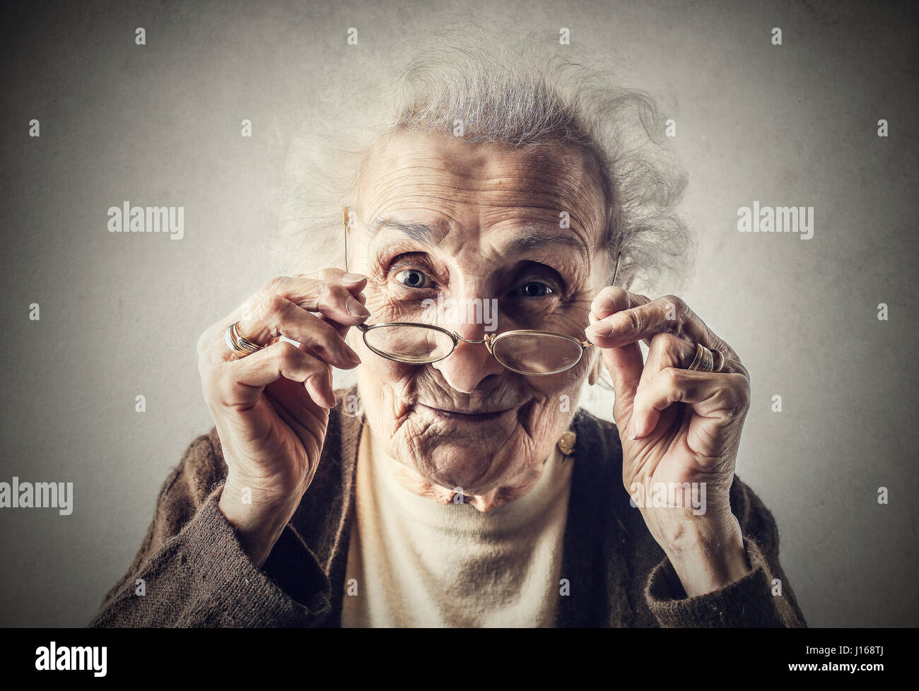 Old lady holding her glasses Stock Photo