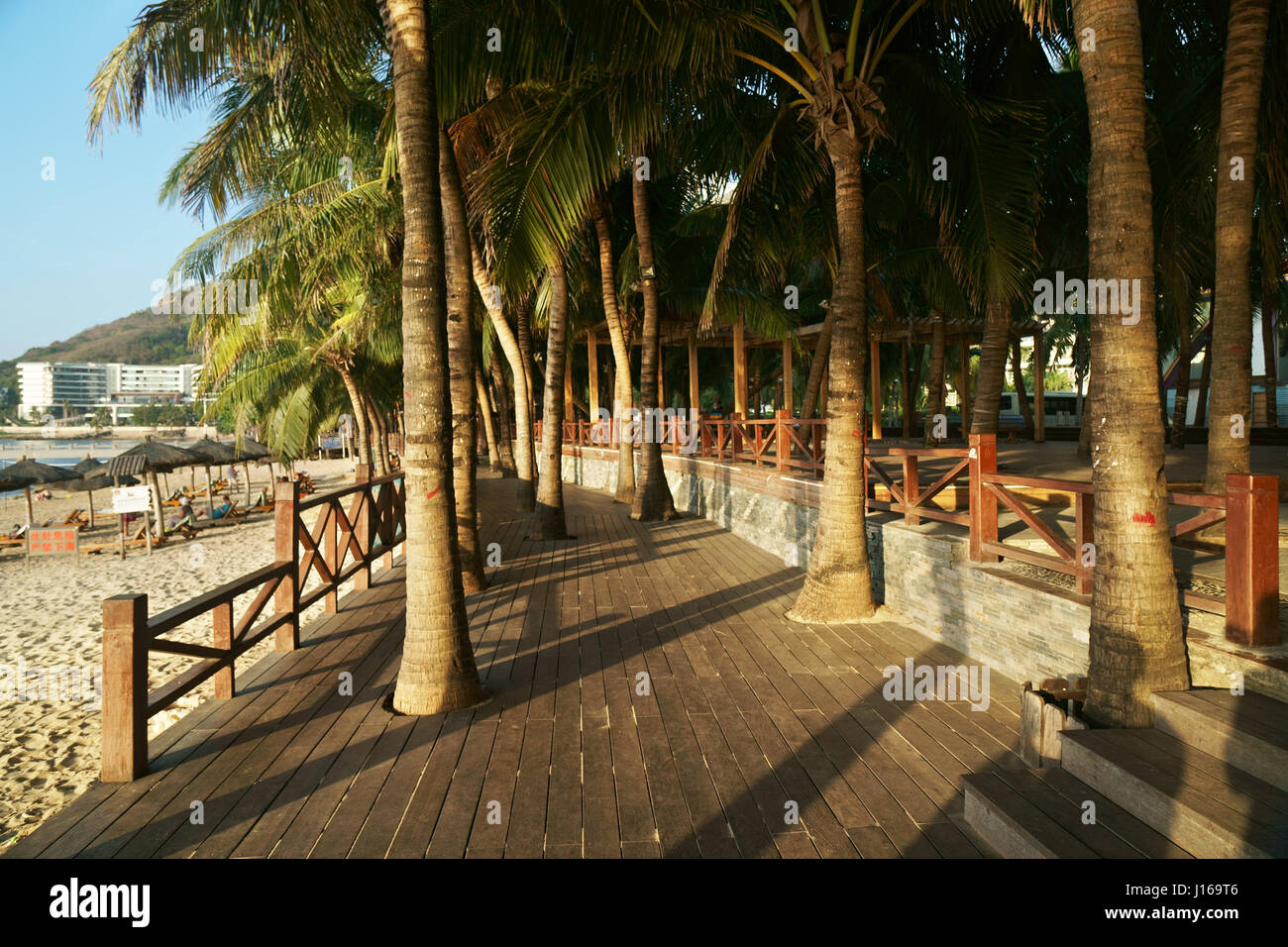 Morning tourist embankment with palm trees along beach at Dadonghai Bay on Hainan Island, China Stock Photo