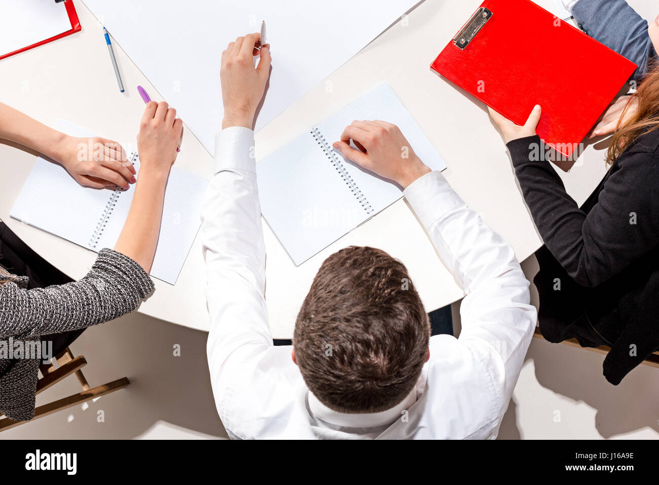 The man sitting behind desk, checking reports, talking. Stock Photo