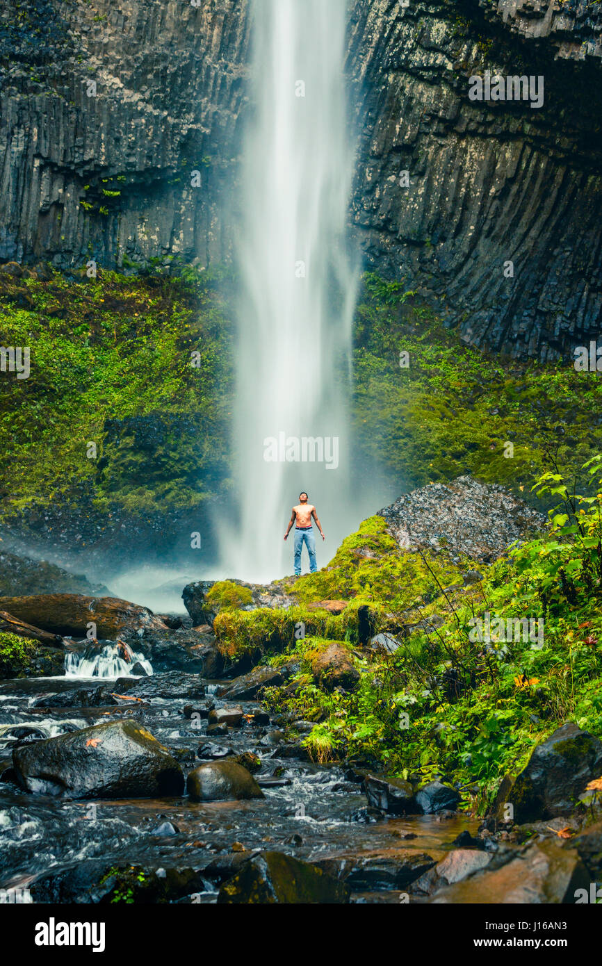 VARIOUS LOCATIONS, WORLDWIDE: A man stands at Latourell Falls, Oregan, USA. FROM an incredibly colourful hot spring to basking in the glory of the stars these pictures show people simply awe-struck by the wonders of our world. One photographer made it his mission to travel the world to celebrate humanity enjoying the most incredible sights in the world – including eye-popping waterfalls, mysterious caverns, the spectacular Northern Lights and even Nevada’s famous Burning Man Festival. Hawaii-based Dustin Wong (31) explained how he came up with the idea for this extraordinary series of sublime  Stock Photo