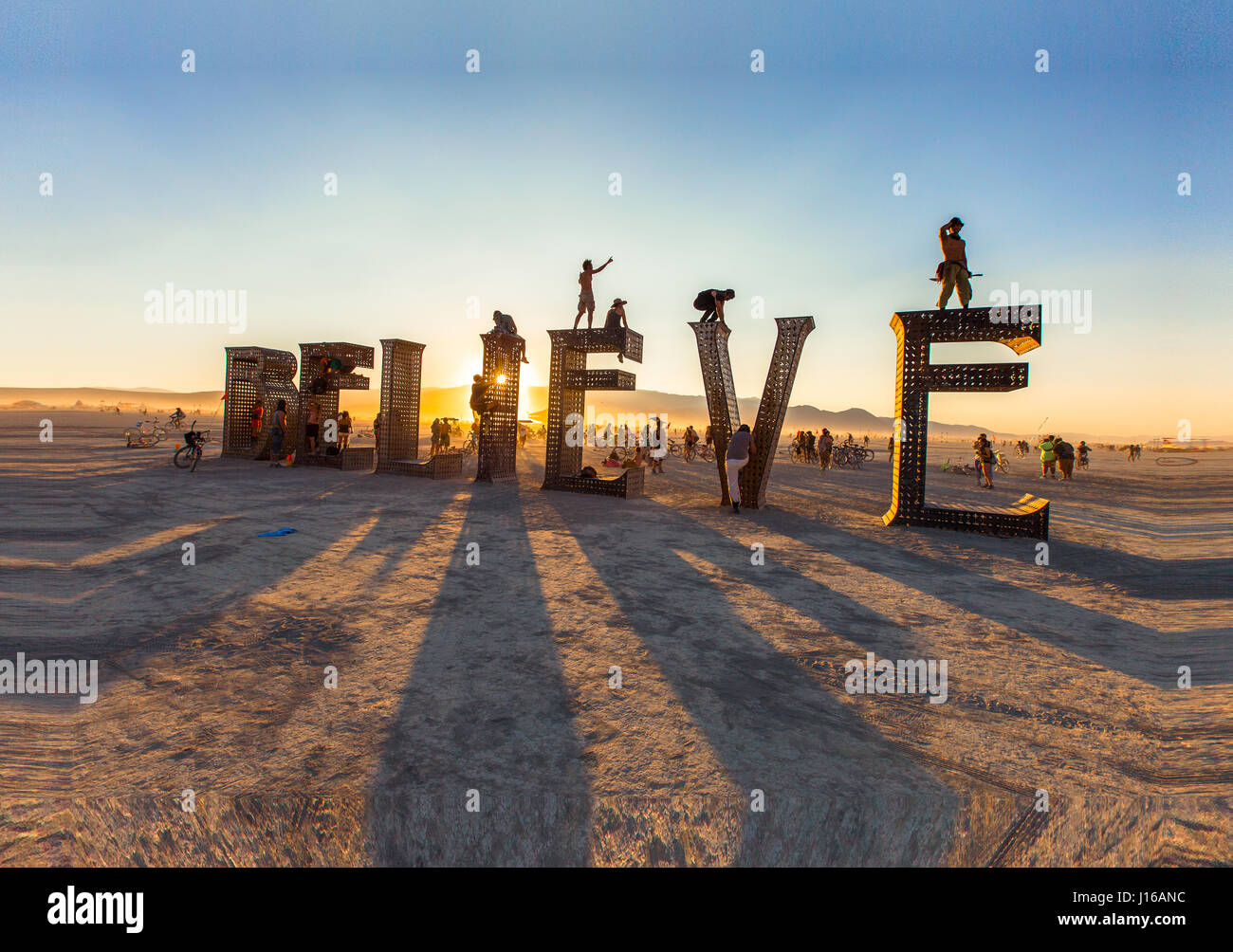 VARIOUS LOCATIONS, WORLDWIDE: 'Believe' topped by revelers at the Burning Man Festival, Nevada, USA. FROM an incredibly colourful hot spring to basking in the glory of the stars these pictures show people simply awe-struck by the wonders of our world. One photographer made it his mission to travel the world to celebrate humanity enjoying the most incredible sights in the world – including eye-popping waterfalls, mysterious caverns, the spectacular Northern Lights and even Nevada’s famous Burning Man Festival. Hawaii-based Dustin Wong (31) explained how he came up with the idea for this extraor Stock Photo