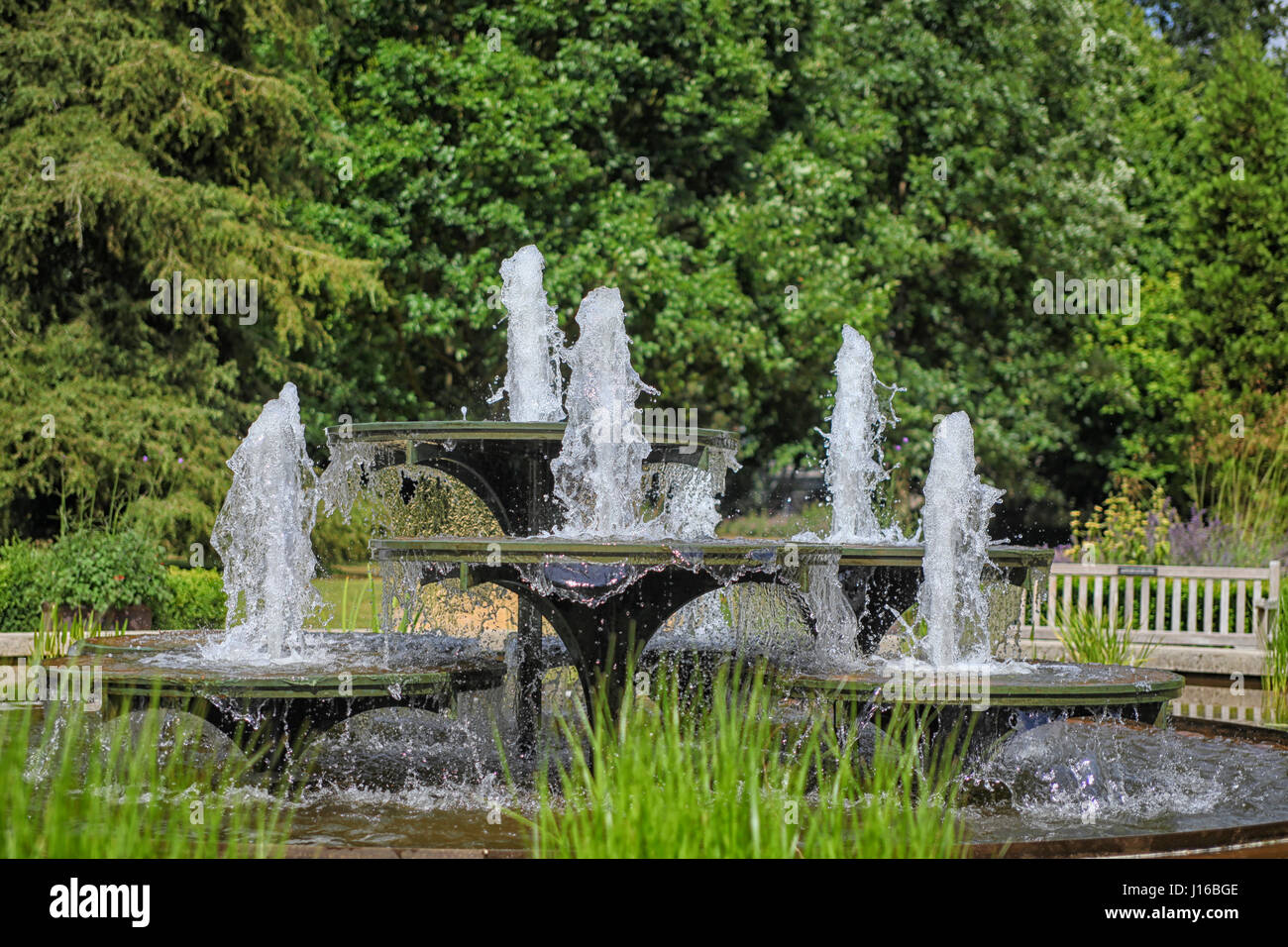 Historical stone fountain in English garden spouting water Stock Photo