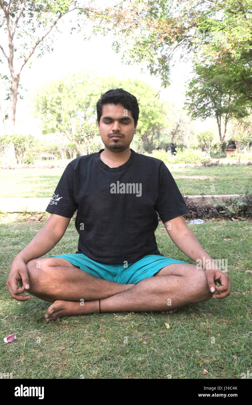 Focused Indian Guy Doing Yoga Asanas, Meditation, Yoga, Morning Garden, New Delhi, India, (Photo Copyright © by Saji Maramon) Stock Photo