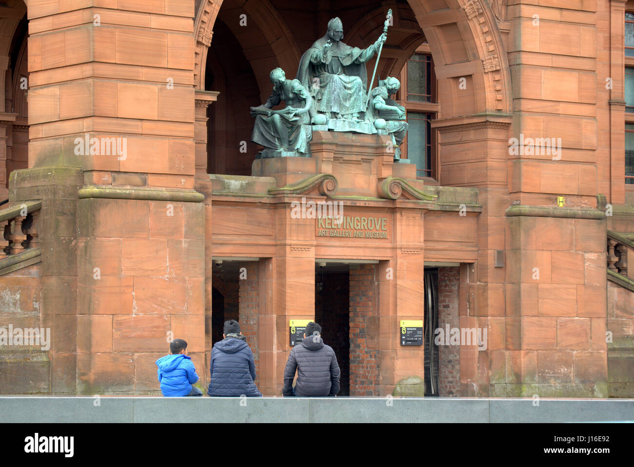 Kelvingrove Art Galleries and Museum front entrance with bishop statue Asian children Stock Photo
