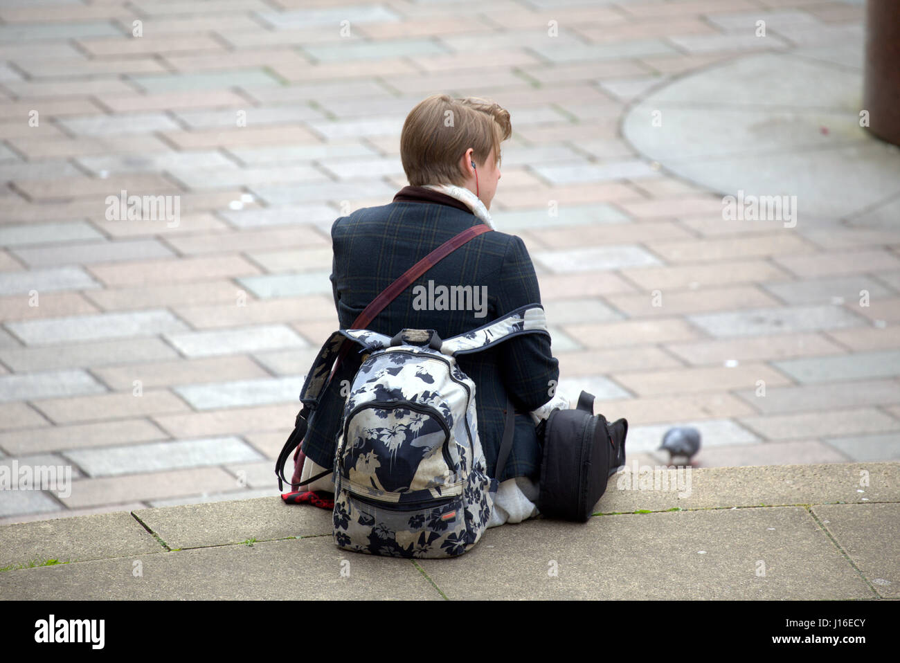 young trendy middle class girl female sitting down with rucksack on Glasgow concert hall steps at the junction of Buchanan street Sauchiehall Street Stock Photo