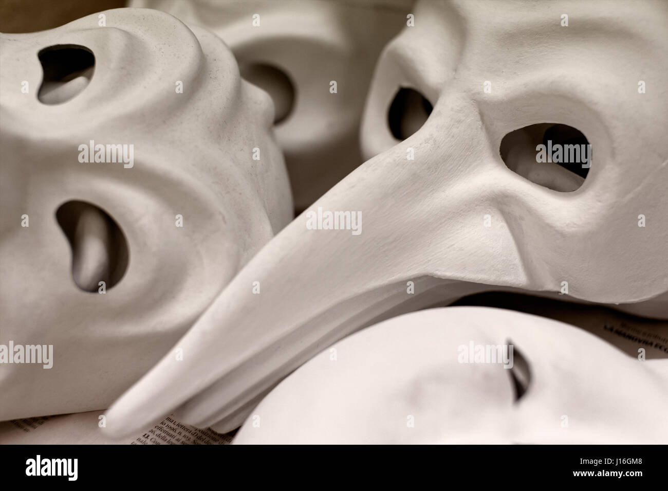 Backgrounds and textures: big group of unfinished traditional Venice masks, plain white paper Stock Photo