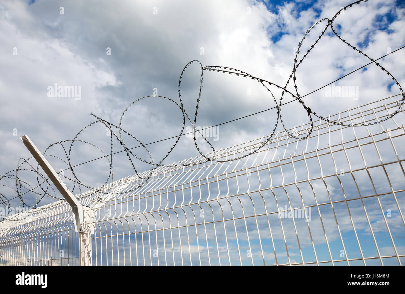 Barbed wire against the blue sky background. Protective fencing
