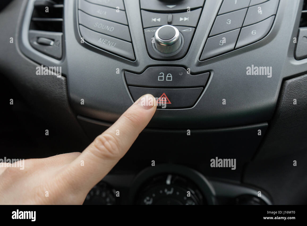 finger pressing car emergency light button Stock Photo