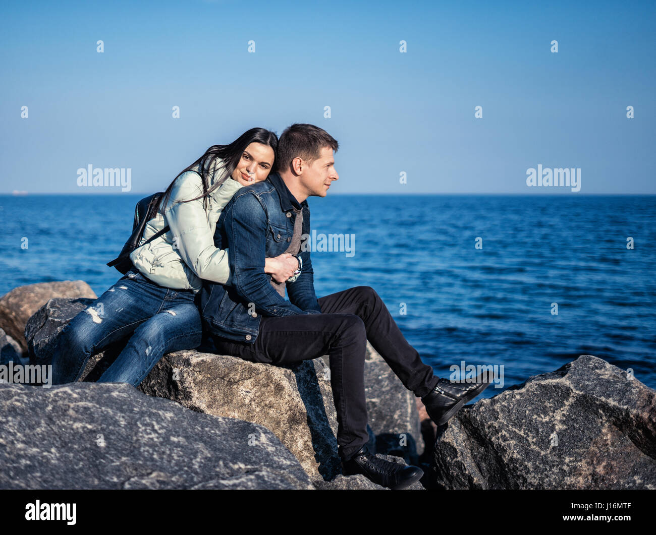 emotional couple sitting on the rocks Stock Photo - Alamy