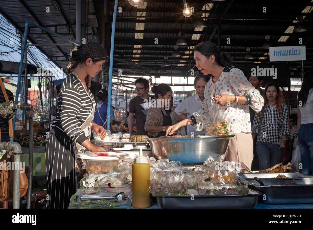 Thailand street market and woman seemingly astounded at prices with a shocked look on her face. Stock Photo