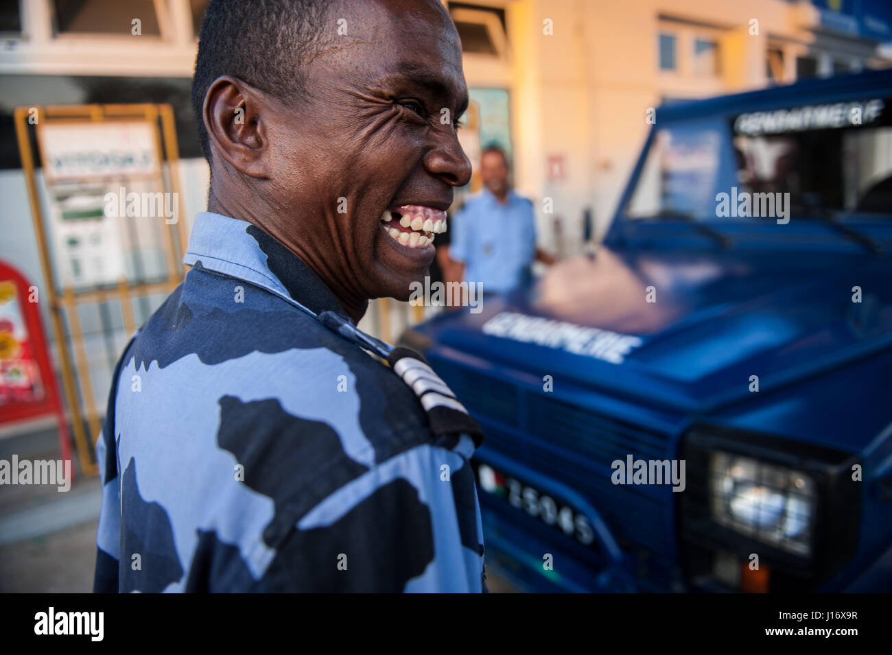 A police officer shares a joke with colleagues at a petrol station in Madagascar's south east city of Taolagnaro, also known as Fort Dauphin Stock Photo