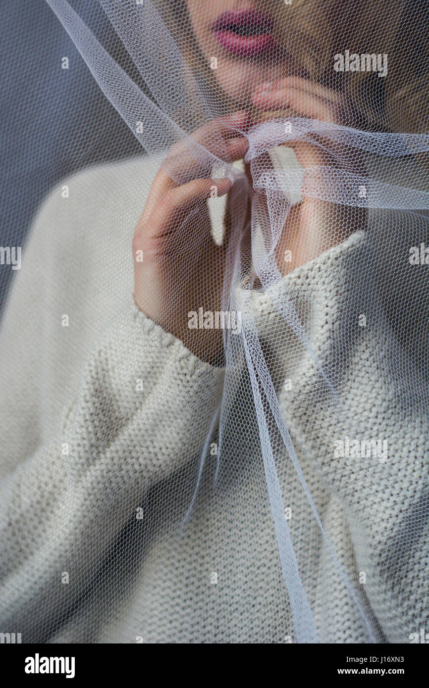 Close up of a woman standing behind a net Stock Photo