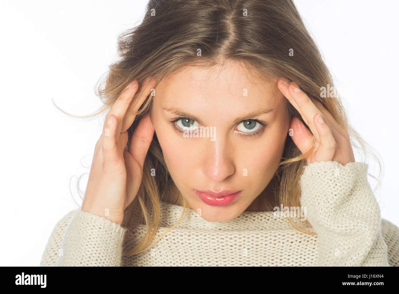 Serious young blond woman hnads on head staring against a white background Stock Photo