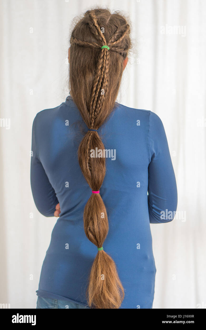 Teardrop plait renaissance hairstyle for long hair. Traditional plait style modelled by girl with very long golden hair Stock Photo