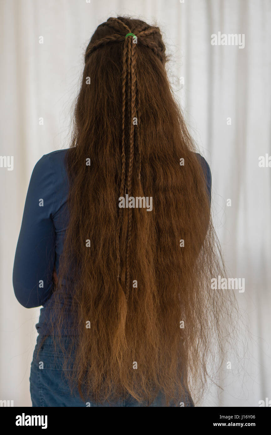 Loose renaissance hairstyle for long hair. Traditional plait style modelled by girl with very long golden hair Stock Photo