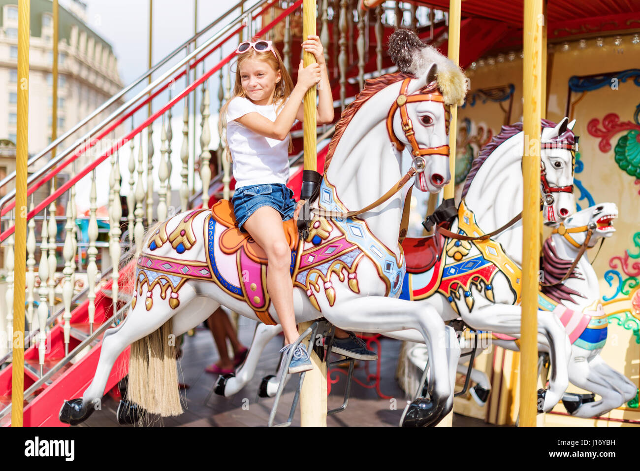 Girl riding on a merry go round. Little girl playing on carousel