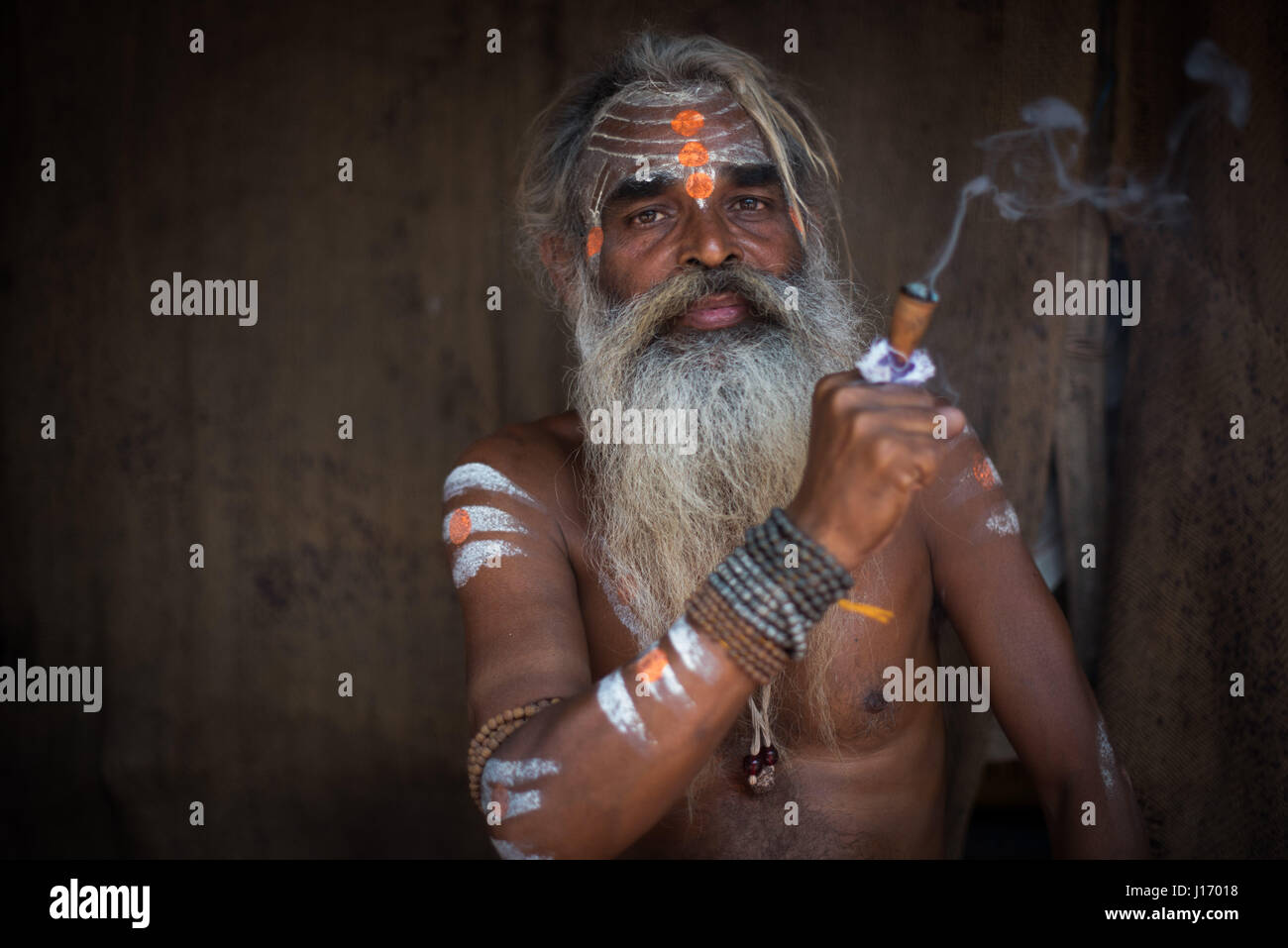 Varanasi holy man (Sadhu) with a smoking pipe Stock Photo