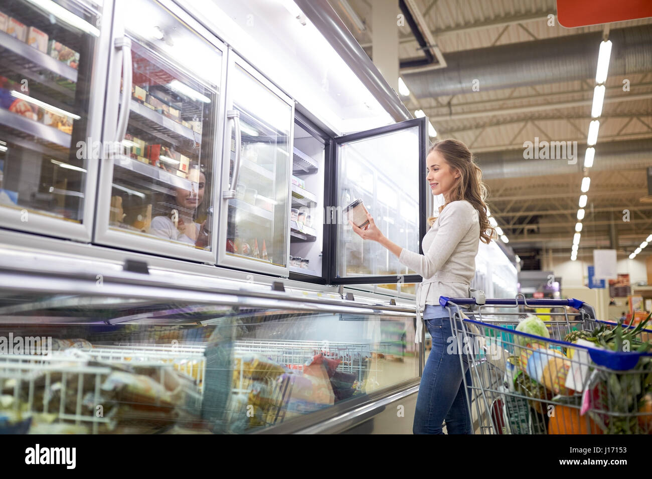 woman choosing ice cream at grocery store freezer Stock Photo Alamy