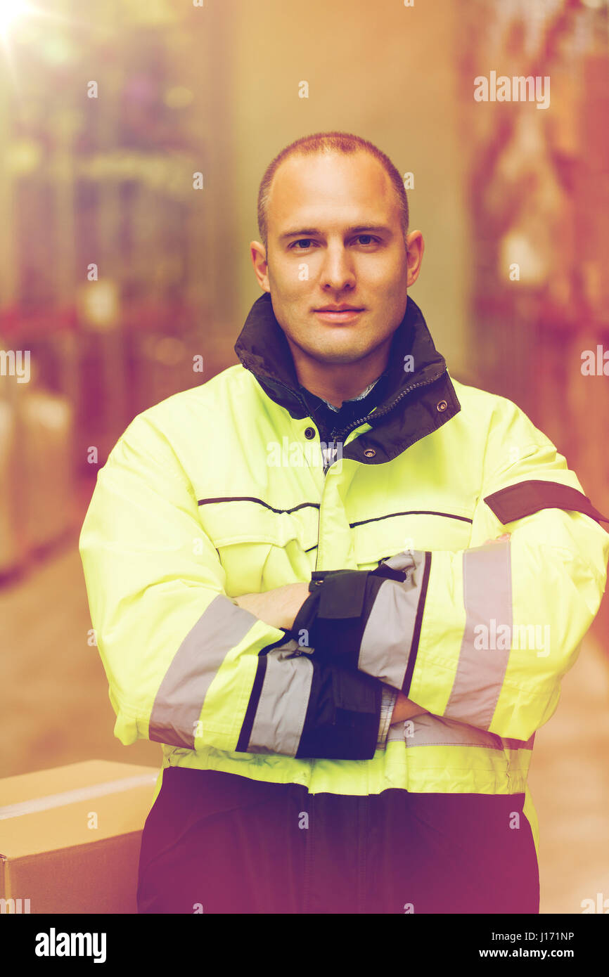 man in coveralls with box at warehouse Stock Photo