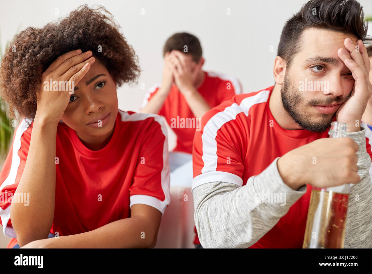 sad friends or football fans at home Stock Photo