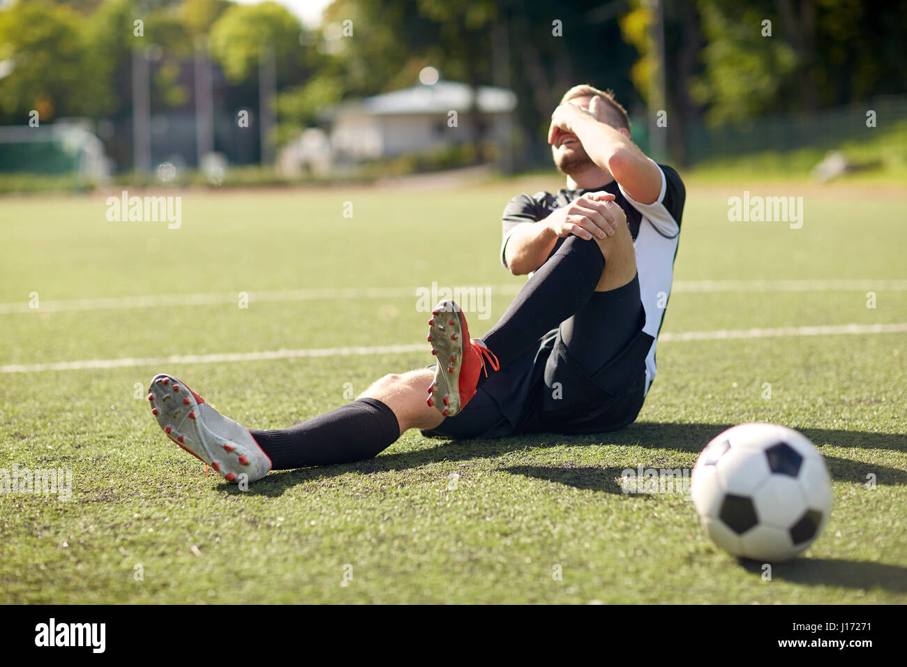 injured soccer player with ball on football field Stock Photo Alamy