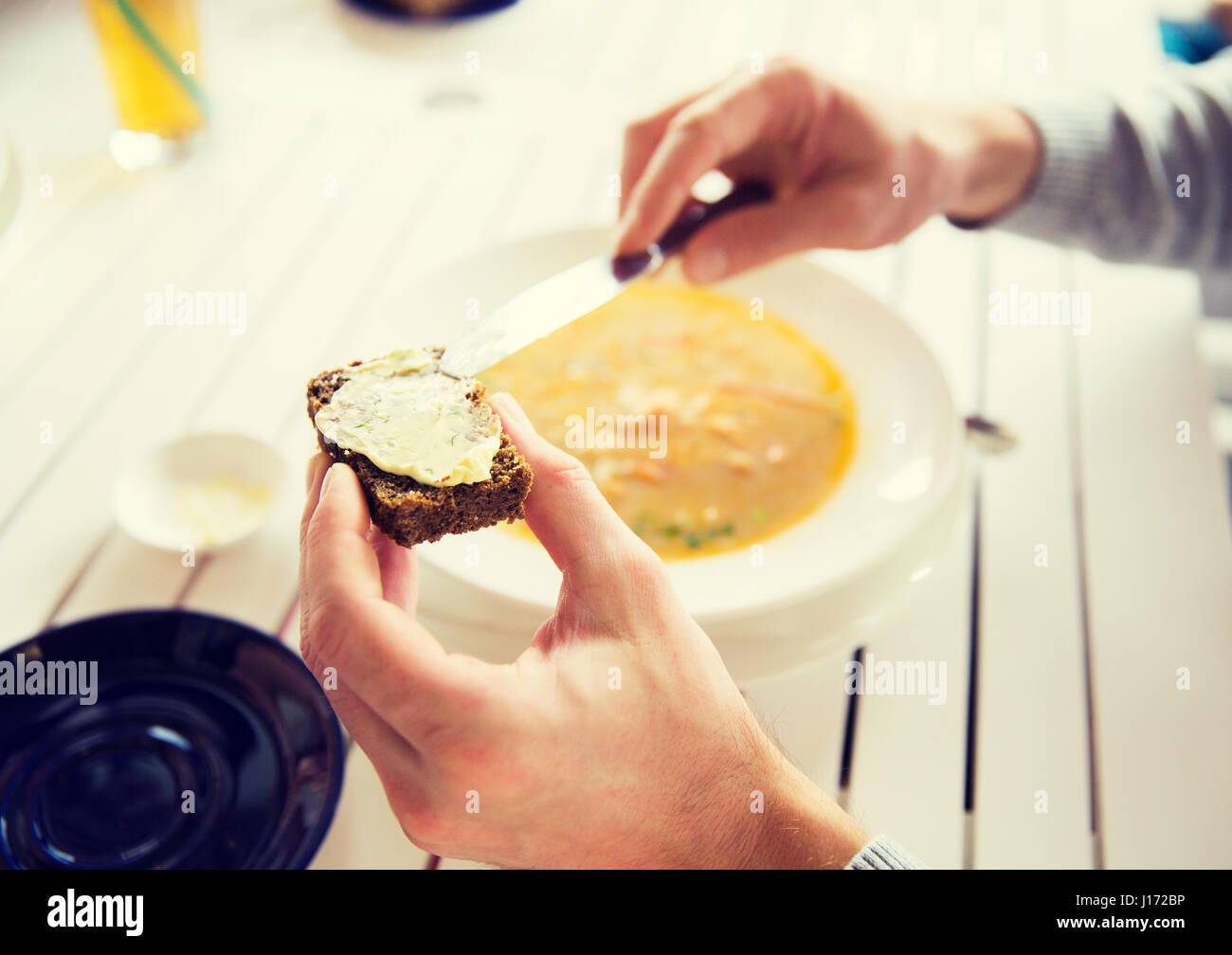 close up of hands applying butter to bread Stock Photo