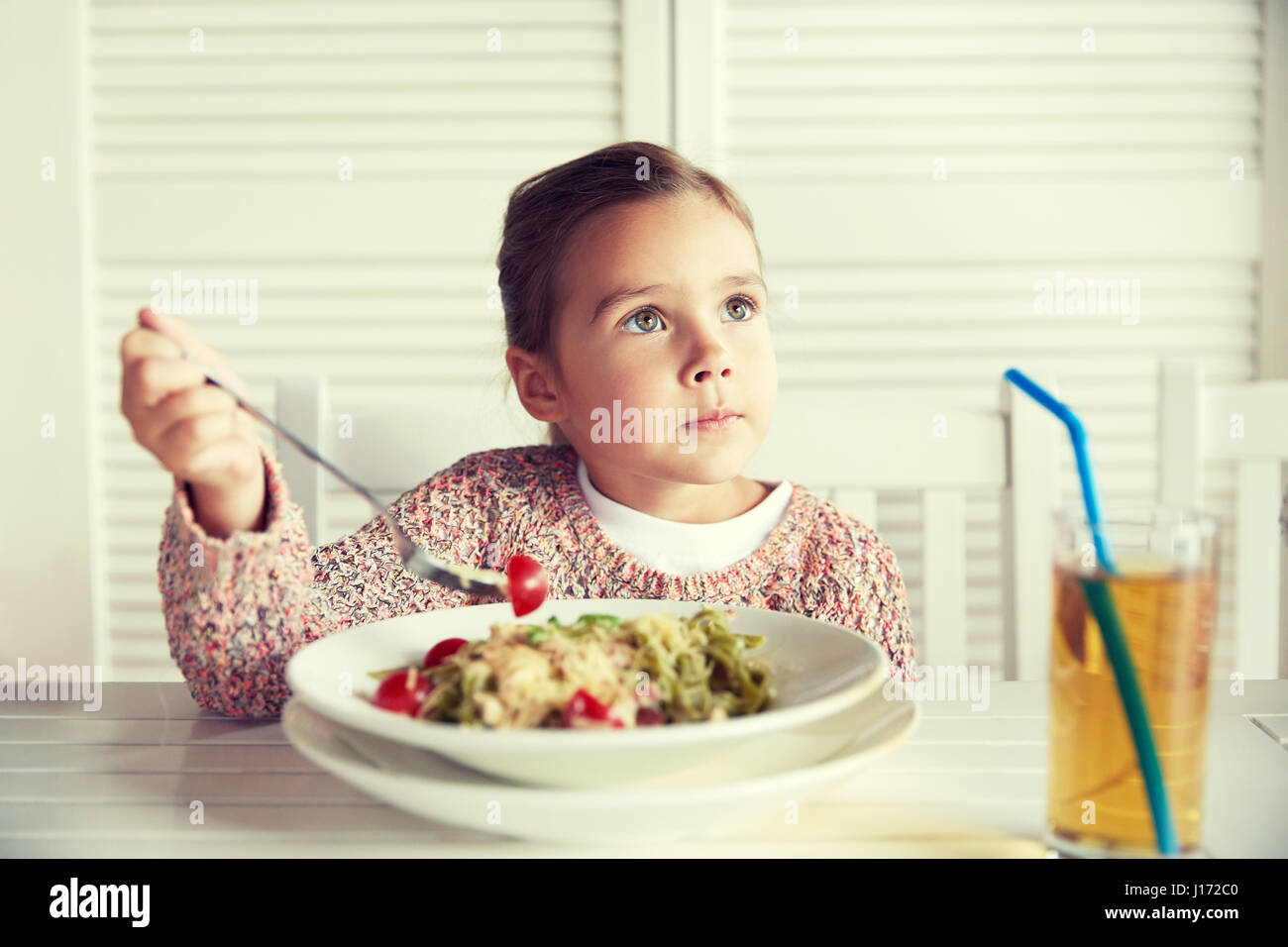 little girl eating pasta for dinner at restaurant Stock Photo