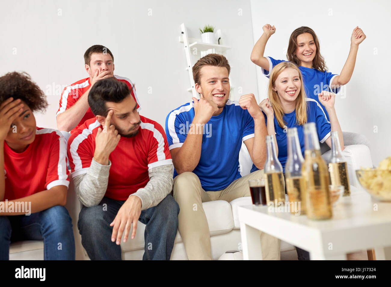 friends or football fans watching soccer at home Stock Photo