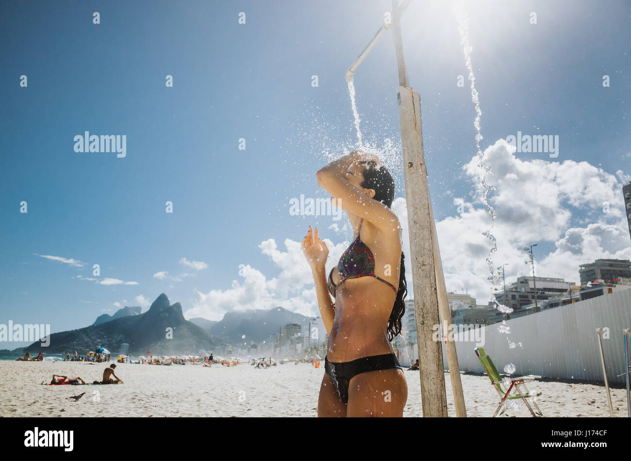 Young woman takes a public shower at Ipanema Beach, Rio de Janeiro