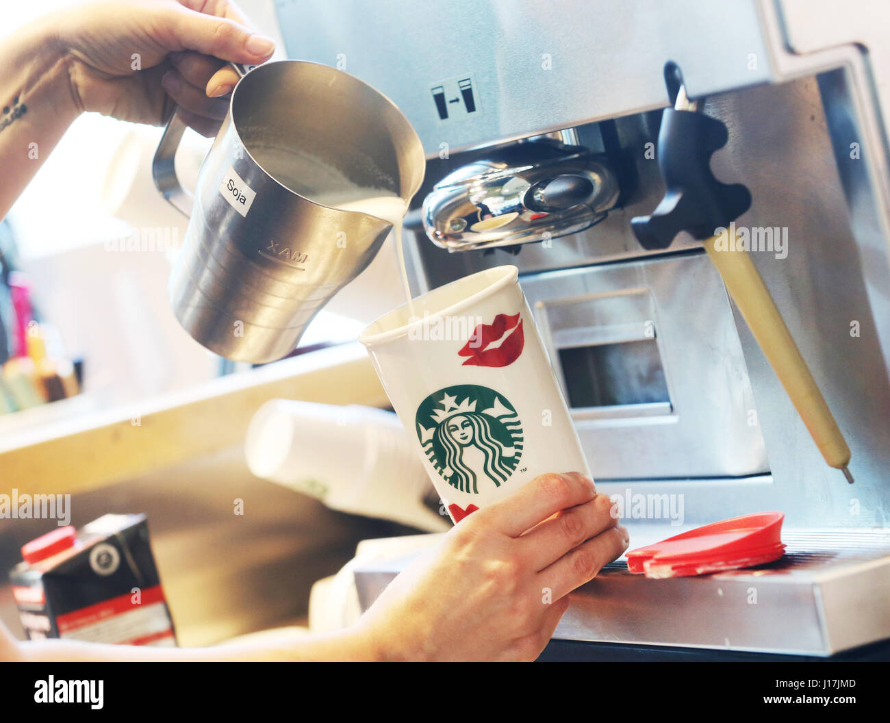 ILLUSTRATION - A Starbucks worker pours a coffee into a reusable cardboard cup in Duisburg, Germany, 19 April 2017. Customers can save 30 cents on their hot beverages if they bring their own cups. Photo: Roland Weihrauch/dpa Stock Photo