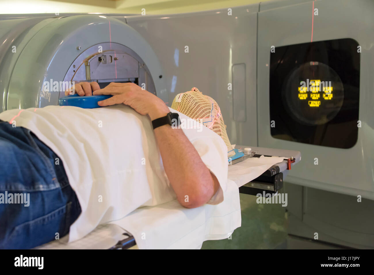 Patient Radiation therapy mask showing laser lines for targeting cancer cells in the brain Stock Photo
