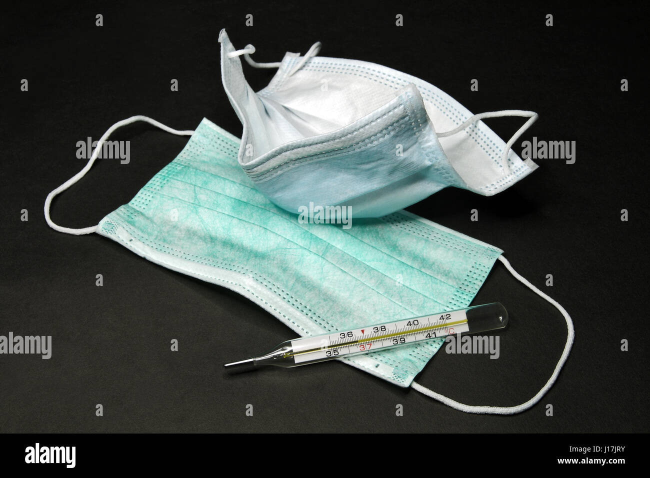 Disposable medical masks and mercury thermometer (testimony of 36.6 C) Stock Photo