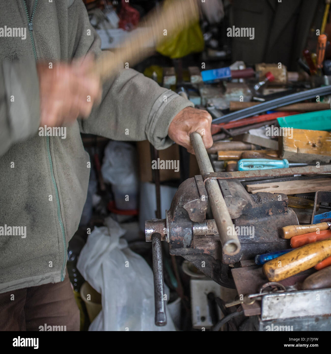 Metalworker works metal with hammer, candid photography Stock Photo