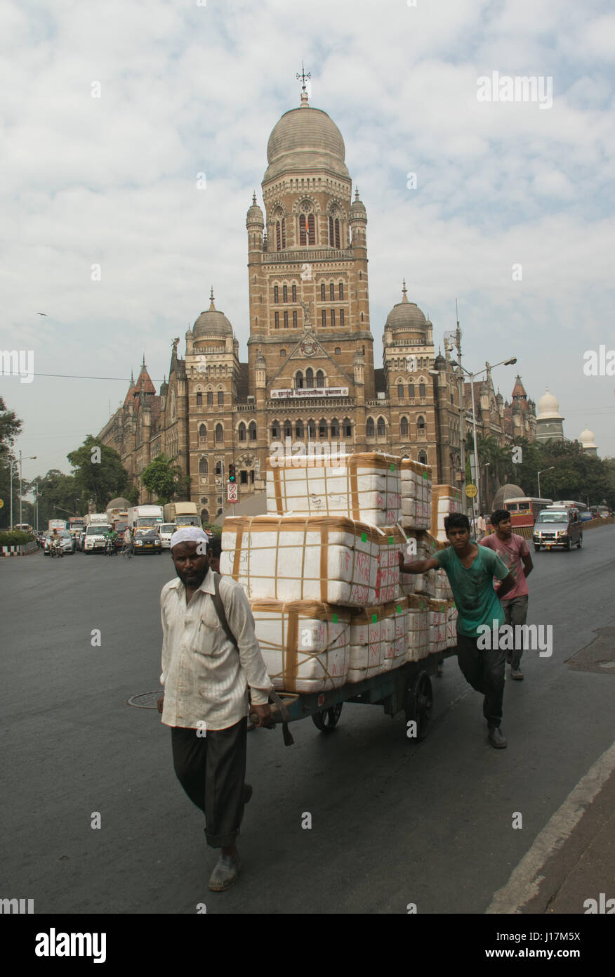 Men pulling cart loaded with packs of goods on street in Mumbai,India Stock Photo