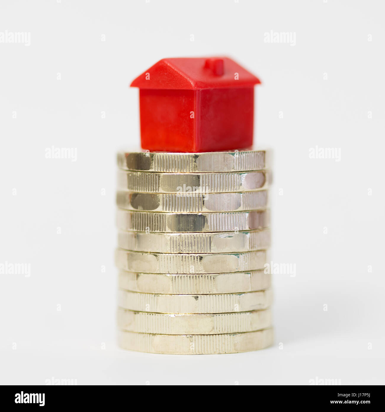 Concept image depicting housing/property markets on stack of new British pound (£) coins. Stock Photo