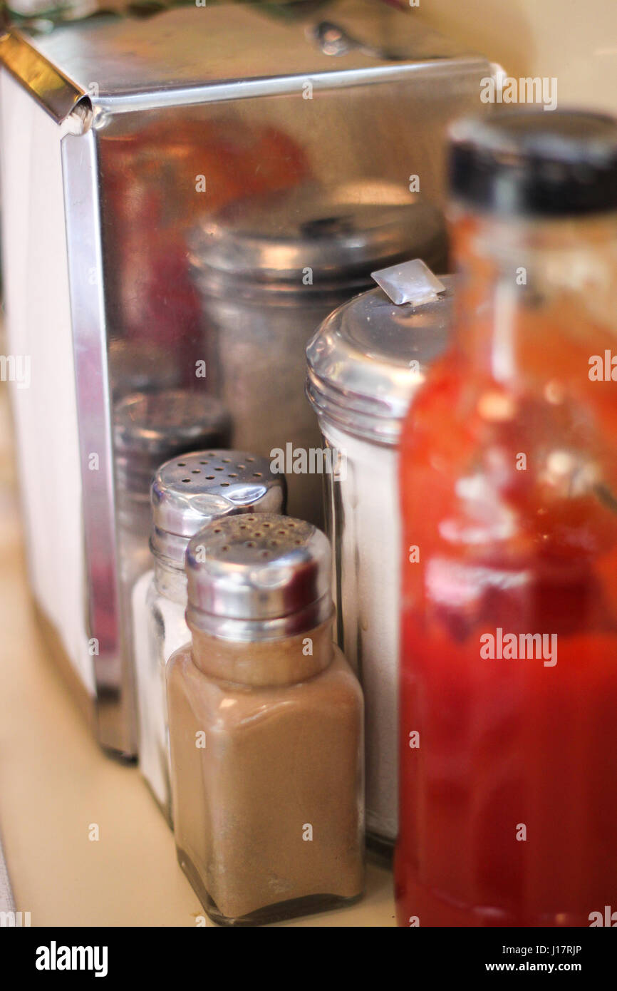 Food. Closeup of condiments salt, pepper, sugar, and a napkin holder in