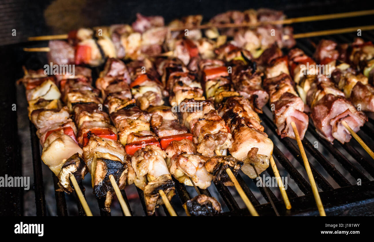 Grilling meat skewers on natural charcoal barbecue grill. Preparing a