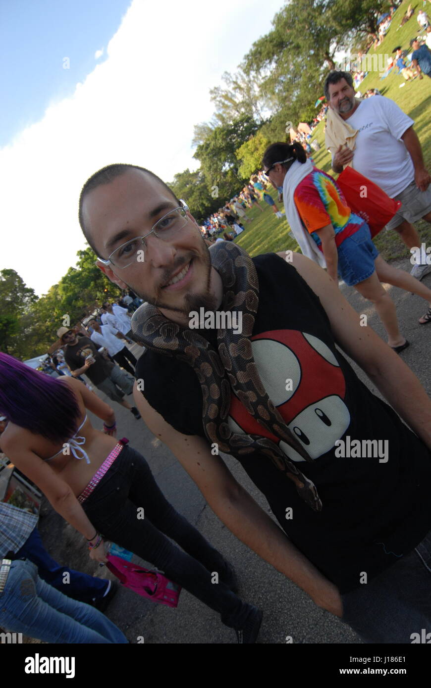 hippy festival love in Miami Florida USA people dressed as 1960's hippies snake around his neck Stock Photo