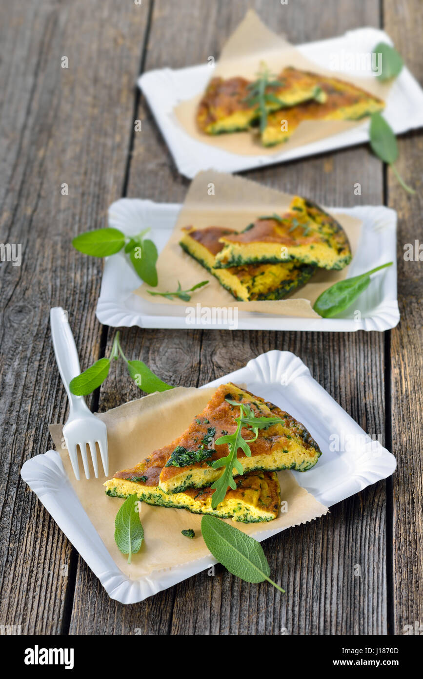 Street food Cuts of delicious herb omelette with parmesan cheese