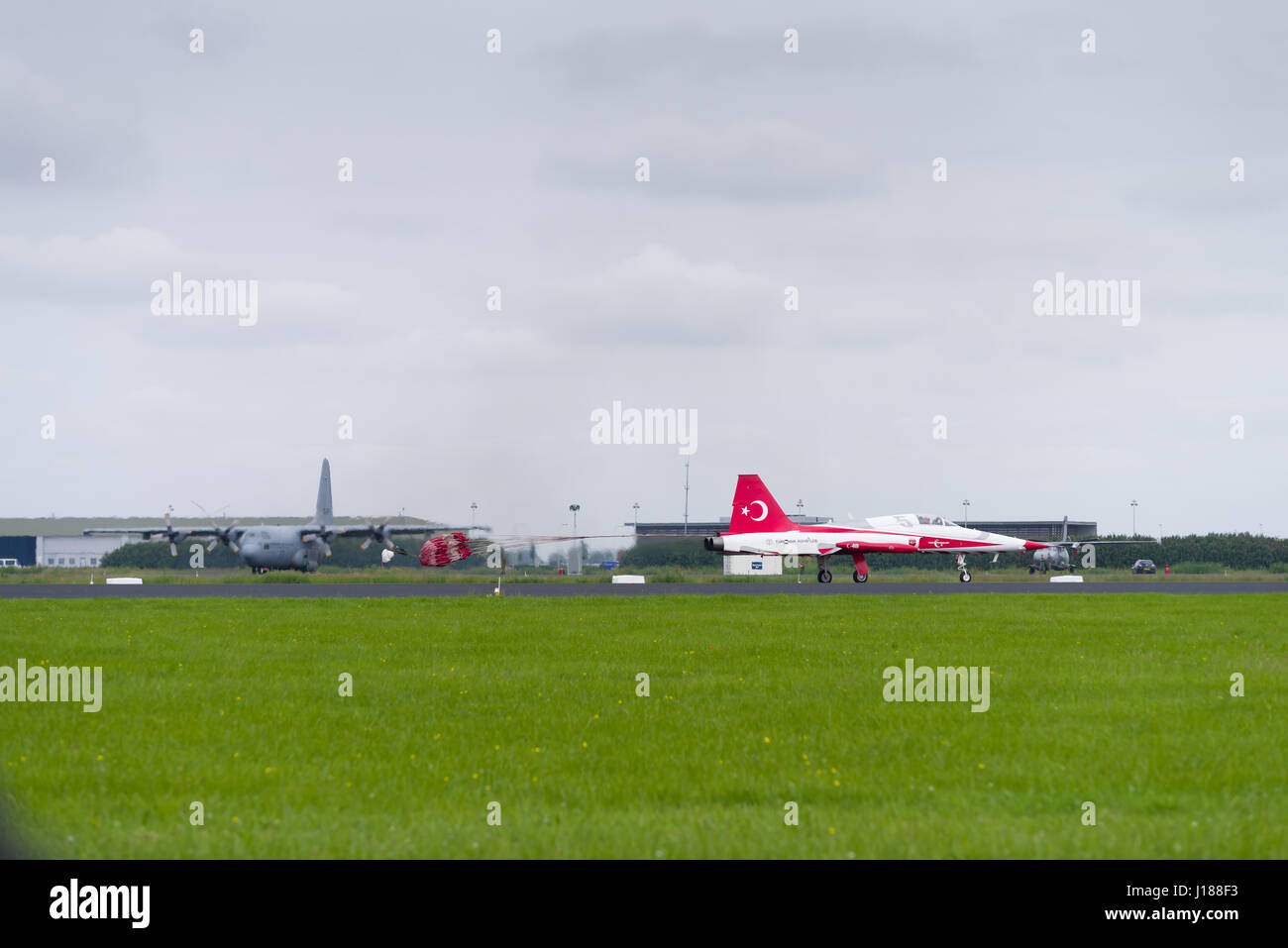 LEEUWARDEN, NETHERLANDS - JUNE 10, 2016: One of the NF-5 Canadair fighter planes of Turkish Star aerobatic demonstration team is landing with a parach Stock Photo