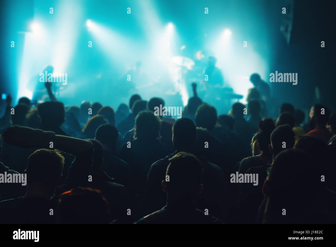 Music concert crowd, people at popular live rock performance, fans hands in the air, selective focus Stock Photo