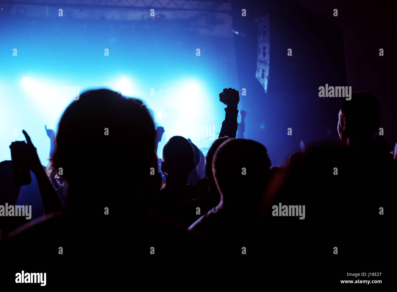 Music concert fans crowd, people at popular live rock performance, hands in the air, selective focus Stock Photo